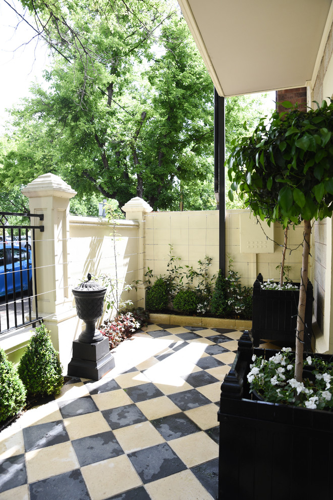 Idee per un piccolo giardino formale tradizionale esposto a mezz'ombra in cortile con pavimentazioni in cemento