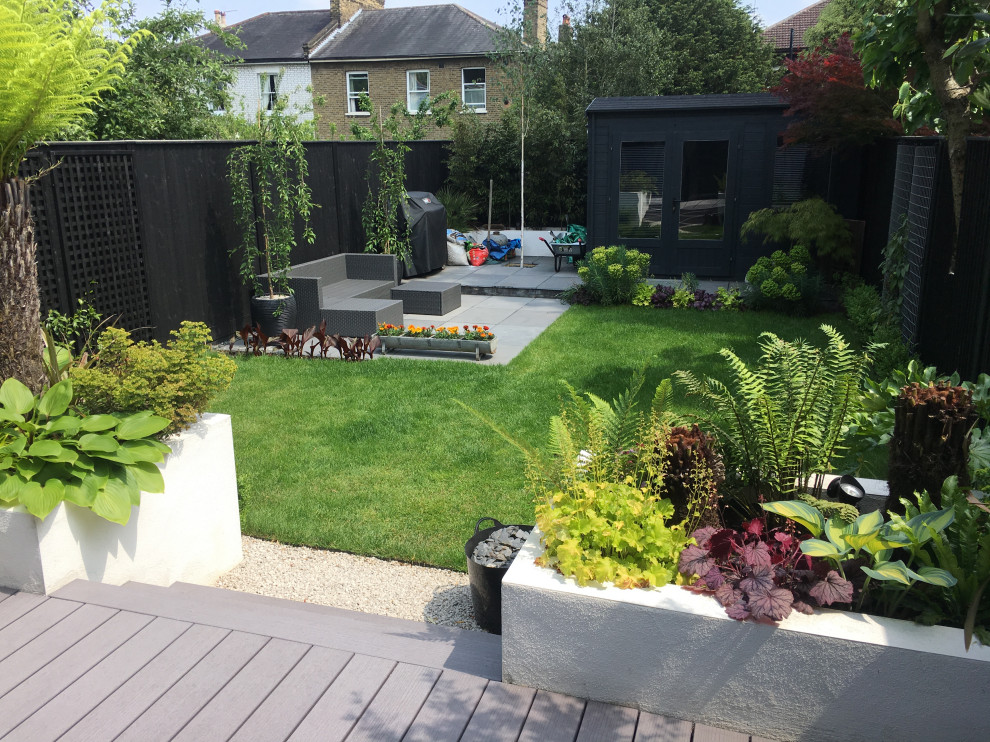 Geometrischer, Mittelgroßer Moderner Garten im Sommer, hinter dem Haus mit Pflastersteinen, Hochbeet und direkter Sonneneinstrahlung in London