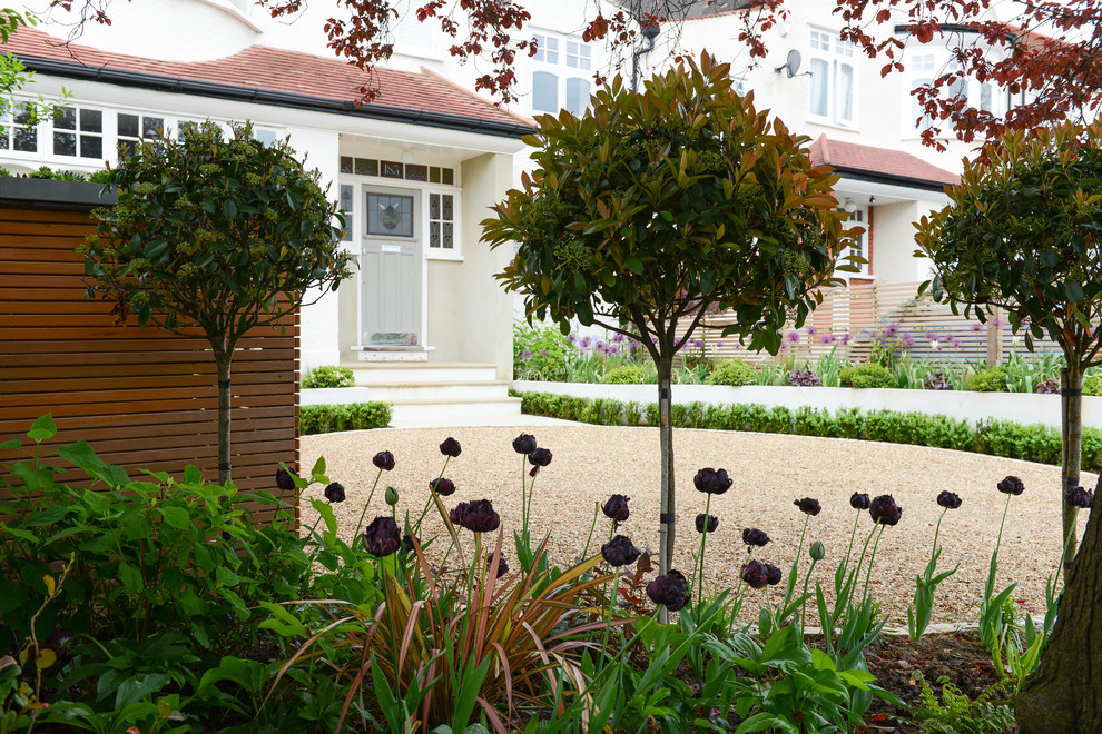 Medium sized contemporary front driveway garden in London with gravel.