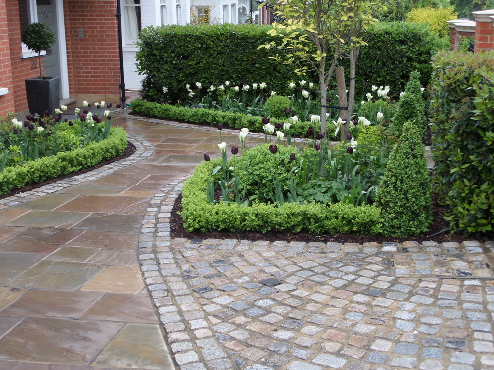Design ideas for a traditional partial sun front yard stone driveway in London.