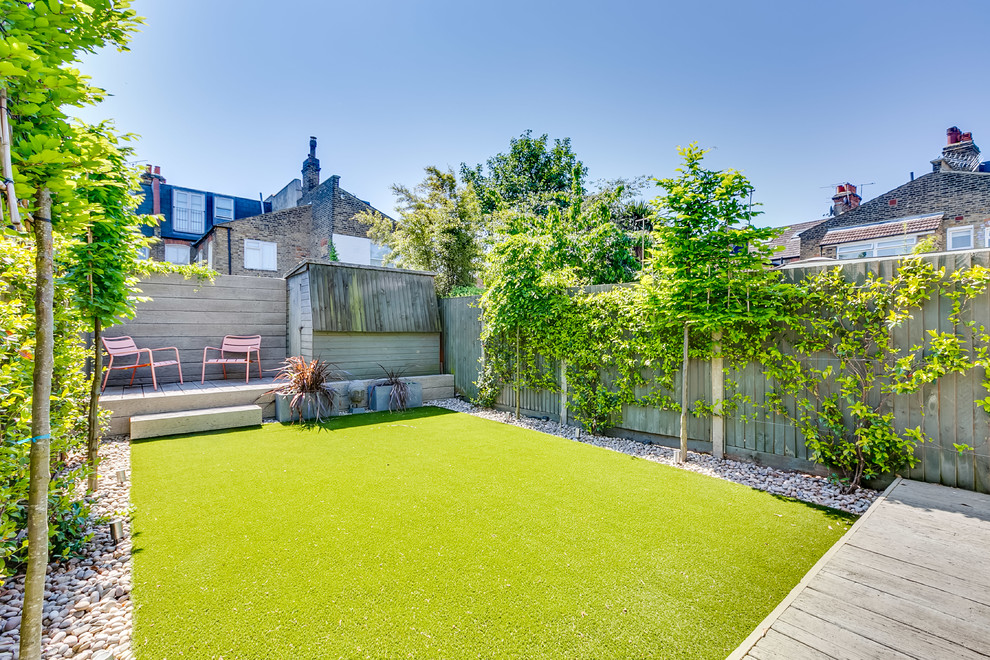 Modelo de jardín actual de tamaño medio en patio trasero con exposición total al sol y entablado