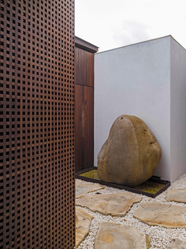 Diseño de jardín de secano minimalista en patio con exposición parcial al sol y gravilla