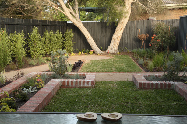 Esempio di un piccolo giardino design esposto a mezz'ombra dietro casa in estate con un muro di contenimento
