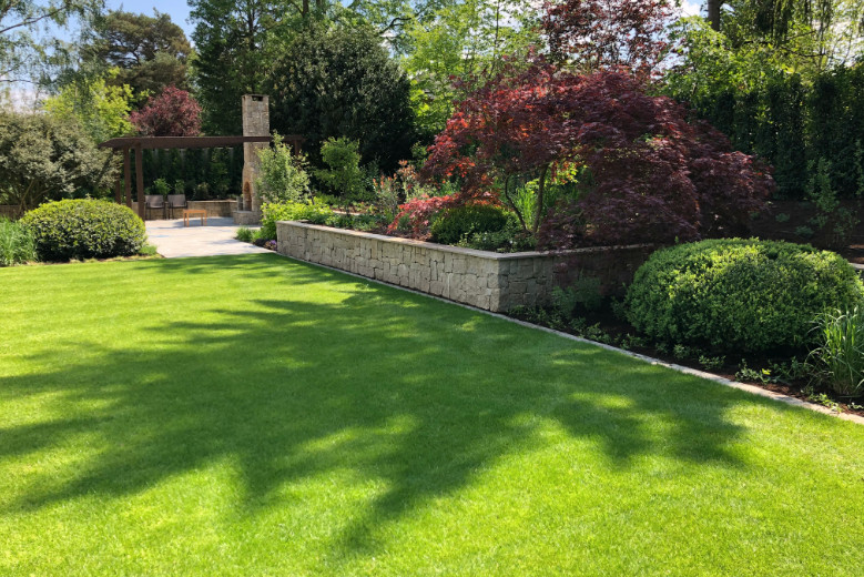 This is an example of a large rural back garden in Other with natural stone paving.