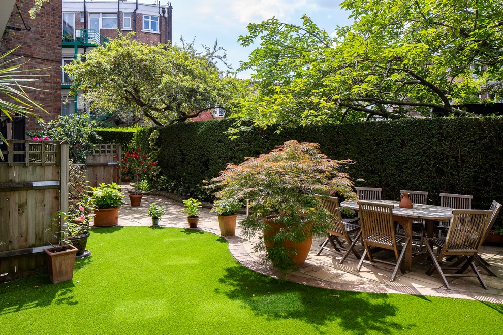 Пример оригинального дизайна: весенний участок и сад среднего размера на заднем дворе в стиле фьюжн с растениями в контейнерах, полуденной тенью и покрытием из каменной брусчатки