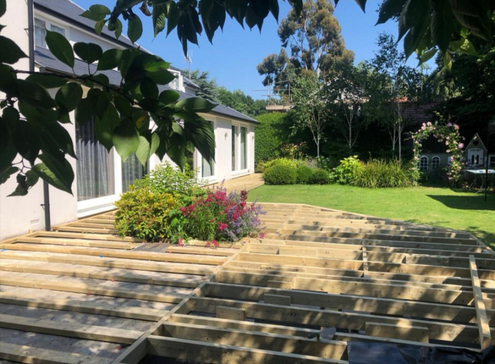 This is an example of a large contemporary back full sun garden for spring in Surrey with decking.