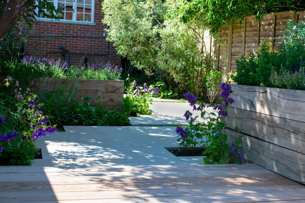 This is an example of a small classic back partial sun garden for summer in Buckinghamshire with decking.