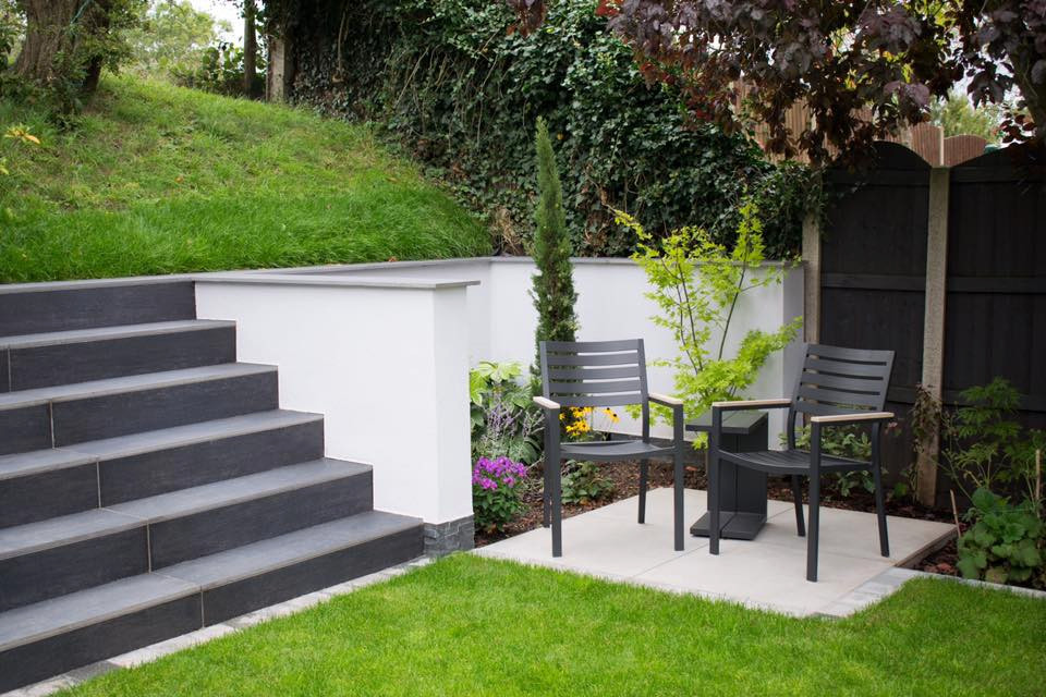 This is an example of a medium sized contemporary back formal garden for summer in West Midlands with a waterfall.