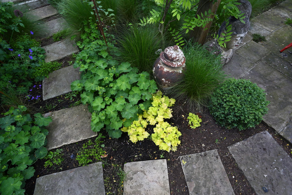 Modelo de jardín tradicional de tamaño medio en verano en patio trasero con jardín francés, exposición parcial al sol y adoquines de piedra natural