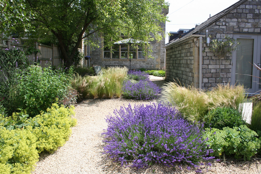 Idée de décoration pour un jardin à la française chalet au printemps avec du gravier.