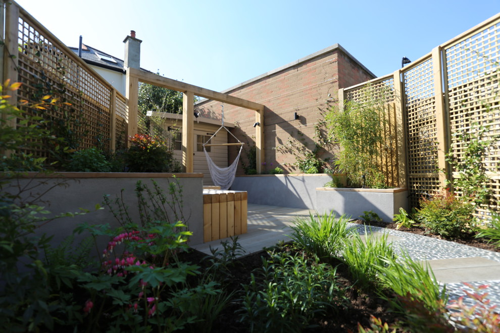 Geometrischer, Kleiner Moderner Garten hinter dem Haus mit Spielgerät und Dielen in London