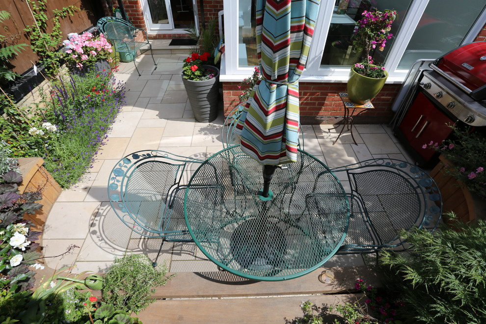 Пример оригинального дизайна: маленький солнечный регулярный сад на заднем дворе в стиле модернизм с местом для костра, хорошей освещенностью и покрытием из каменной брусчатки для на участке и в саду
