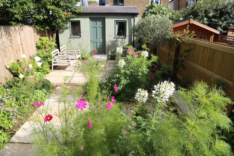 Diseño de jardín rural pequeño en verano en patio trasero con jardín francés, exposición total al sol y adoquines de piedra natural