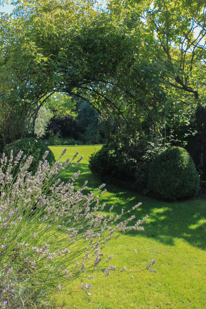 Inspiration for a traditional formal partial sun garden for spring in Sussex with a garden path.