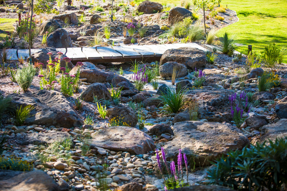Cette photo montre un très grand jardin arrière l'été avec une exposition ensoleillée et des galets de rivière.