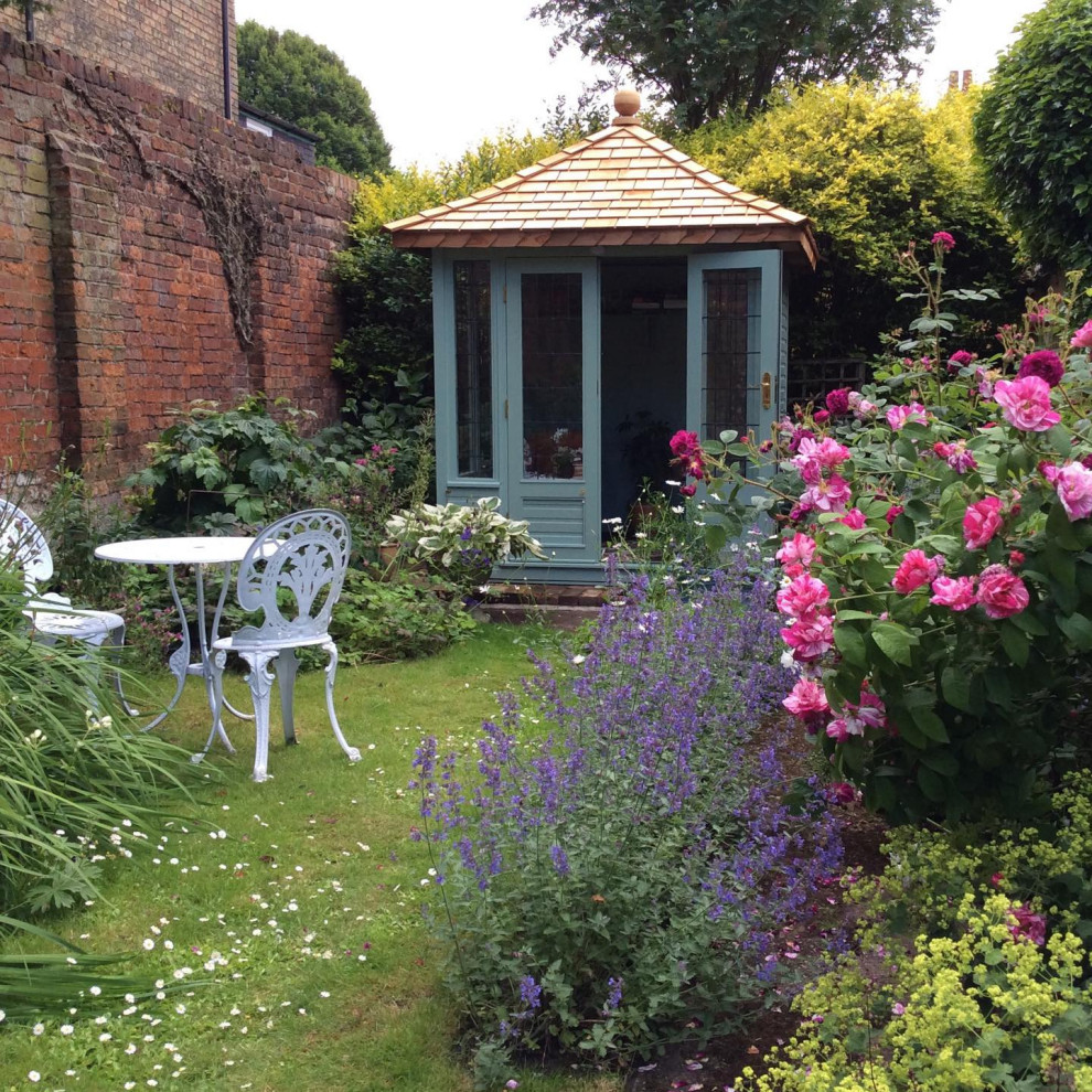 На фото: солнечный, летний участок и сад на заднем дворе в классическом стиле с хорошей освещенностью и забором с