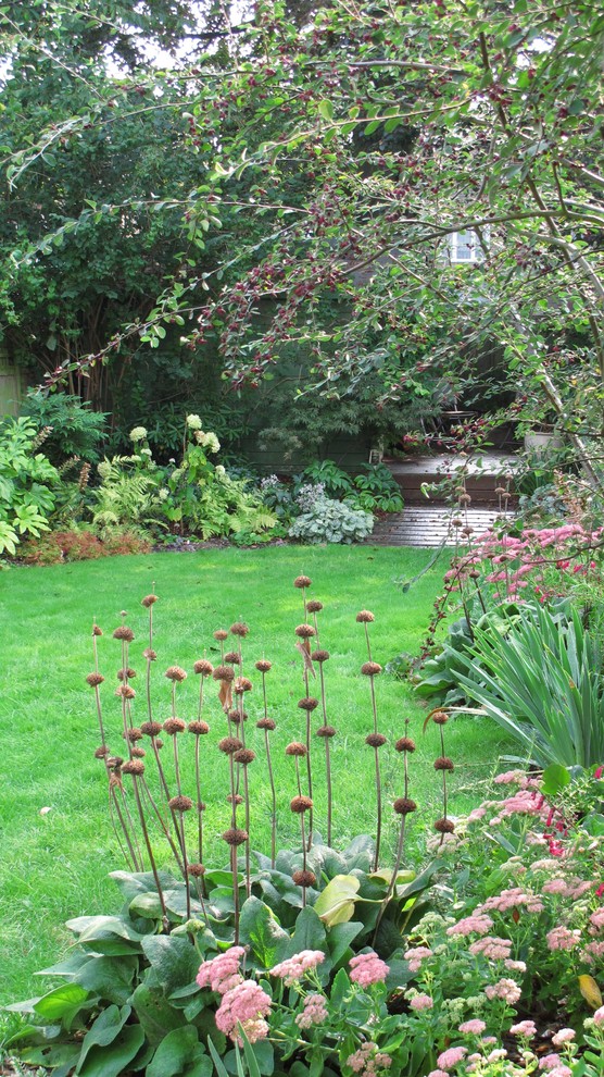 Ejemplo de jardín tradicional grande en verano en patio trasero con exposición parcial al sol y entablado
