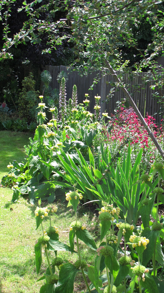Immagine di un giardino classico esposto in pieno sole di medie dimensioni e dietro casa in estate con pavimentazioni in pietra naturale
