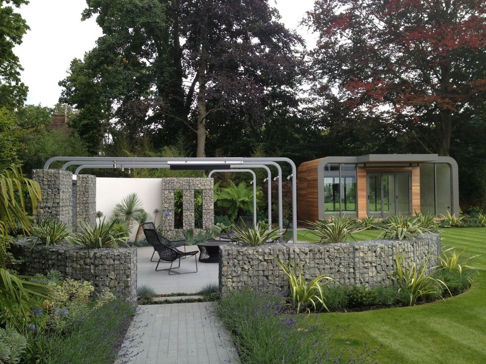 На фото: летний регулярный сад среднего размера на заднем дворе в современном стиле с полуденной тенью и покрытием из каменной брусчатки с
