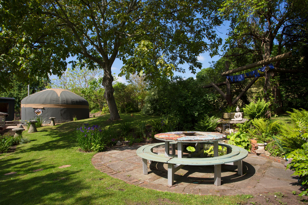 Imagen de jardín exótico grande en patio trasero con fuente y exposición parcial al sol