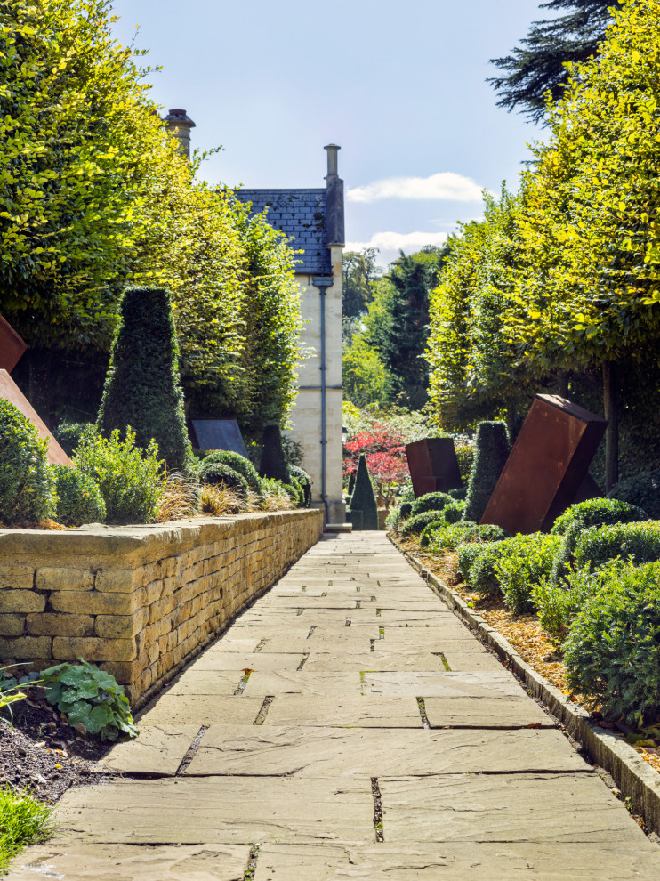 Cette image montre un jardin design avec un chemin, une exposition ensoleillée et des pavés en pierre naturelle.