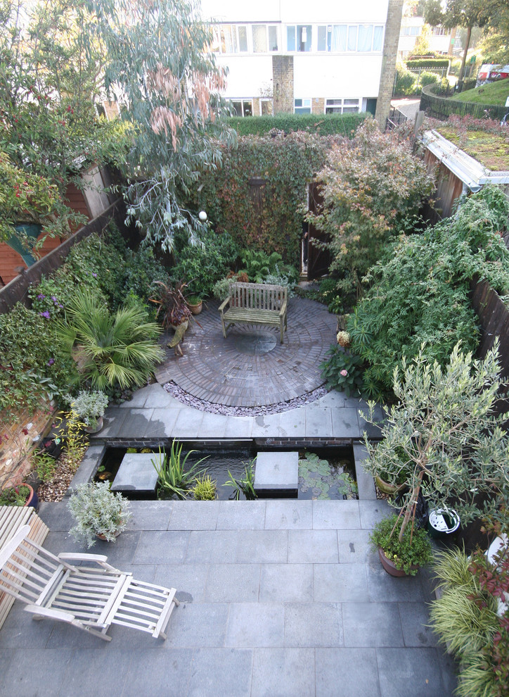 Esempio di un giardino contemporaneo esposto in pieno sole dietro casa con fontane e pavimentazioni in mattoni