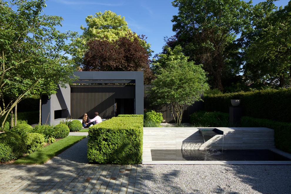 Photo of a mid-sized contemporary backyard gravel landscaping in London.