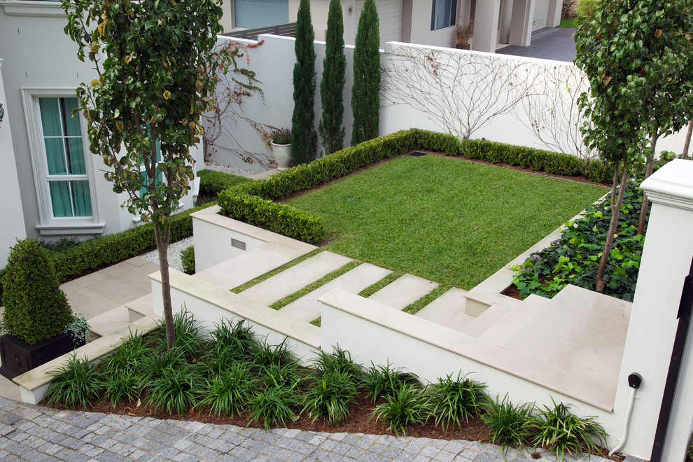 Esempio di un piccolo giardino minimal esposto in pieno sole davanti casa con un ingresso o sentiero e pavimentazioni in pietra naturale