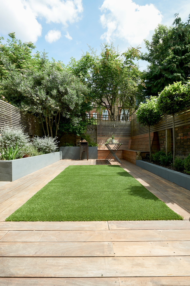 Halbschattiger Moderner Kiesgarten hinter dem Haus mit Kübelpflanzen in London