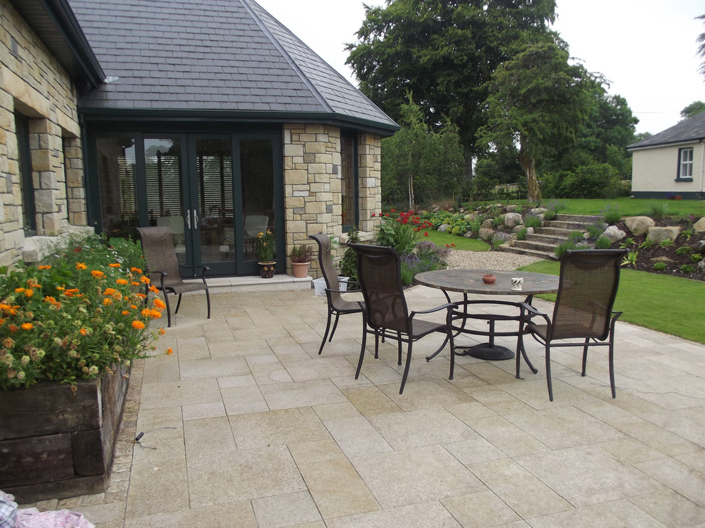 Diseño de patio de estilo de casa de campo grande en patio trasero con huerto y adoquines de piedra natural