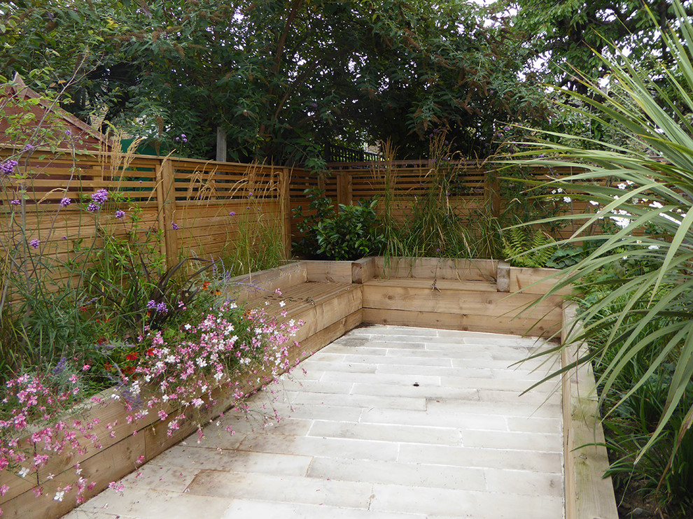 Inspiration for a small contemporary drought-tolerant and full sun backyard stone landscaping in London for summer.
