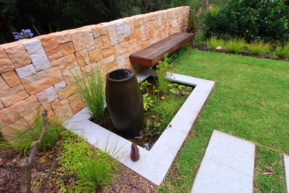 Large modern back full sun garden for spring in Sydney with brick paving.