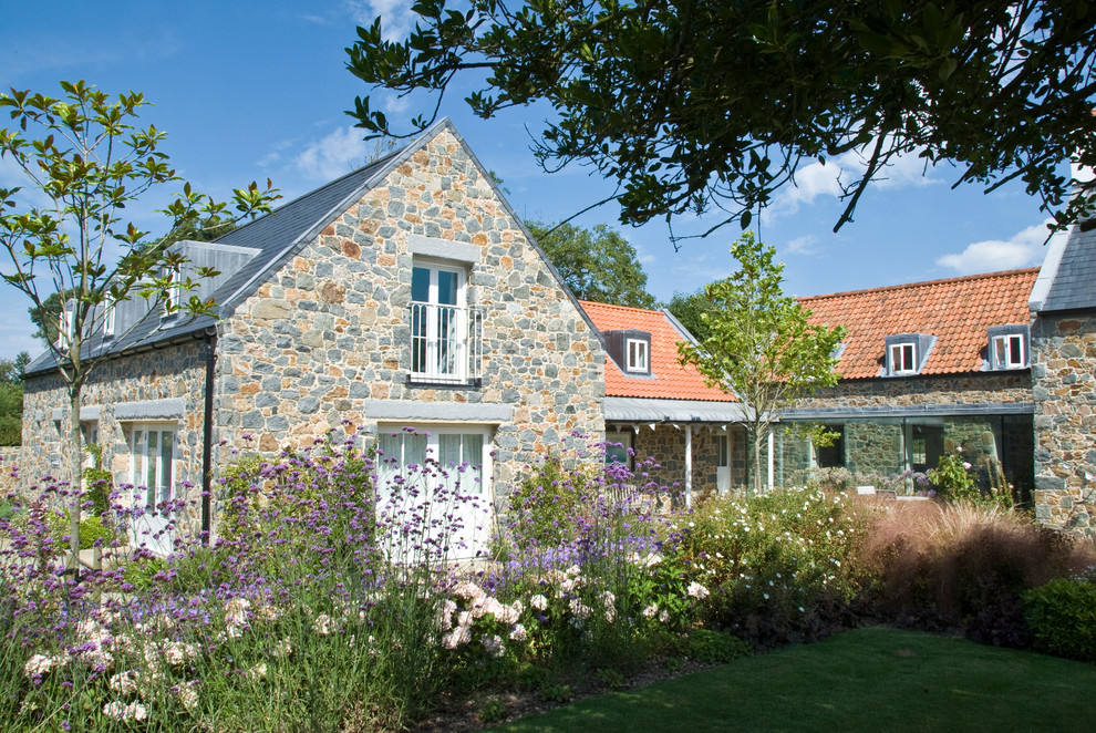 Foto di un grande giardino country esposto in pieno sole dietro casa in estate con pavimentazioni in pietra naturale