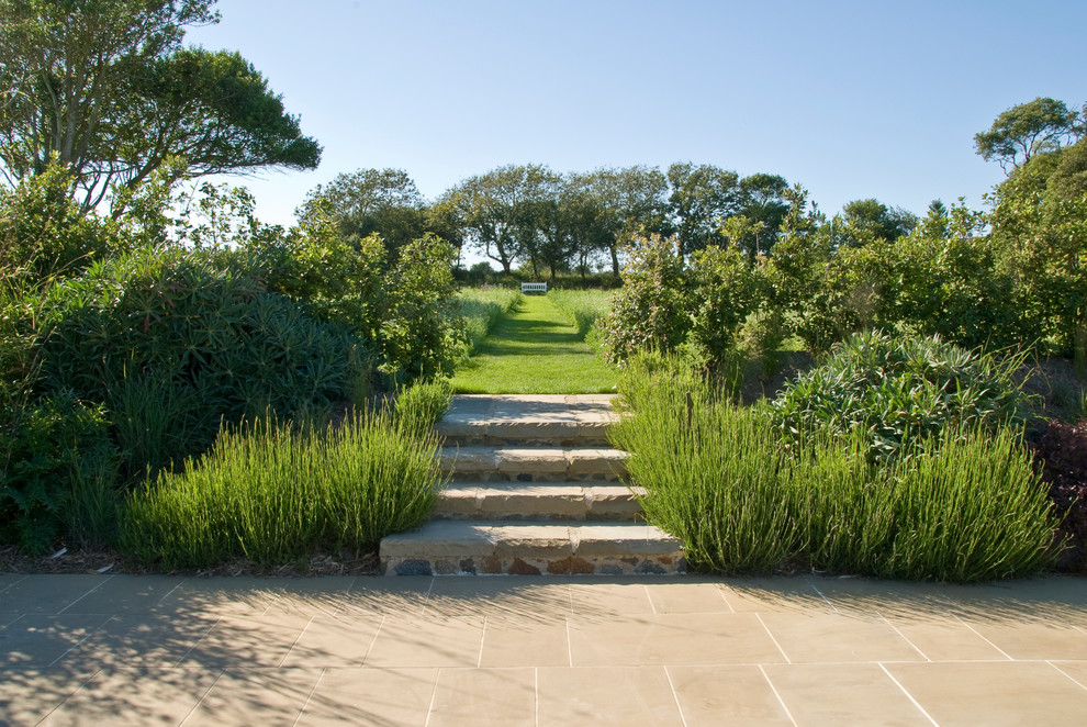 Photo of a large farmhouse full sun backyard stone garden path in Channel Islands for summer.
