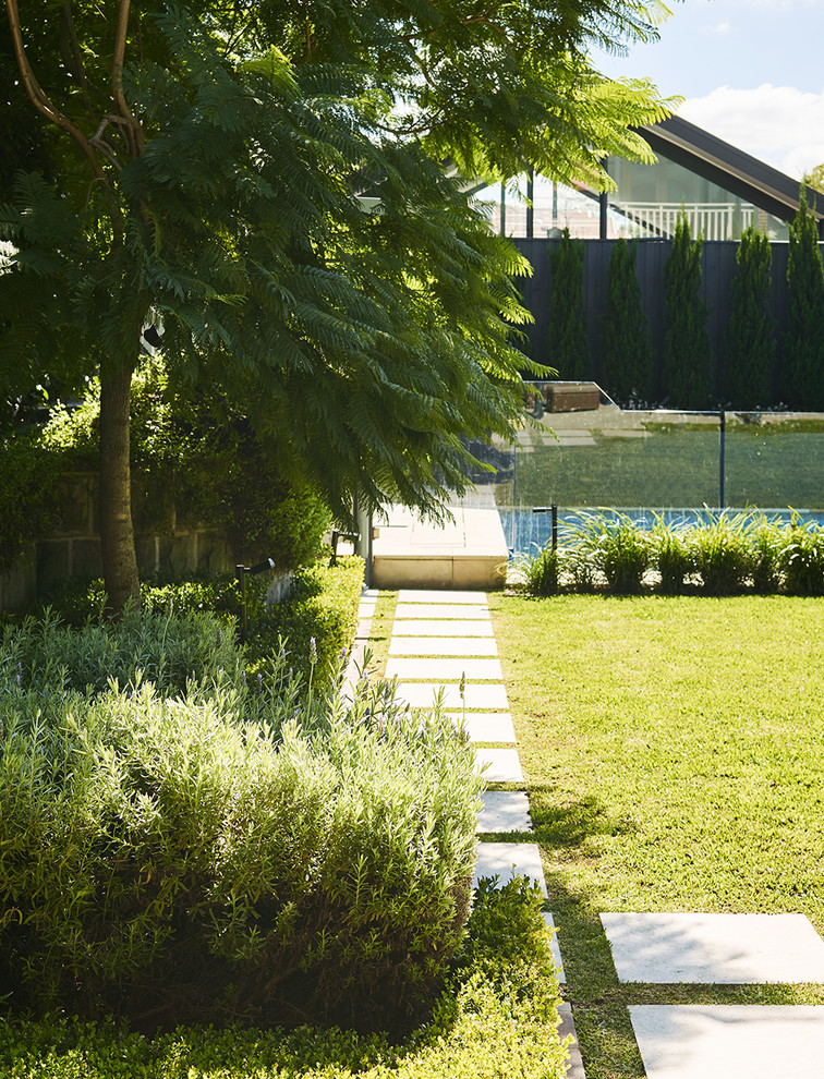 Modelo de jardín contemporáneo grande en patio trasero con jardín francés