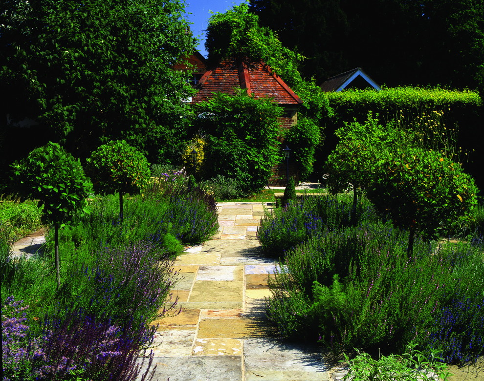 Foto di un grande orto in giardino classico esposto in pieno sole in cortile in primavera con pavimentazioni in pietra naturale