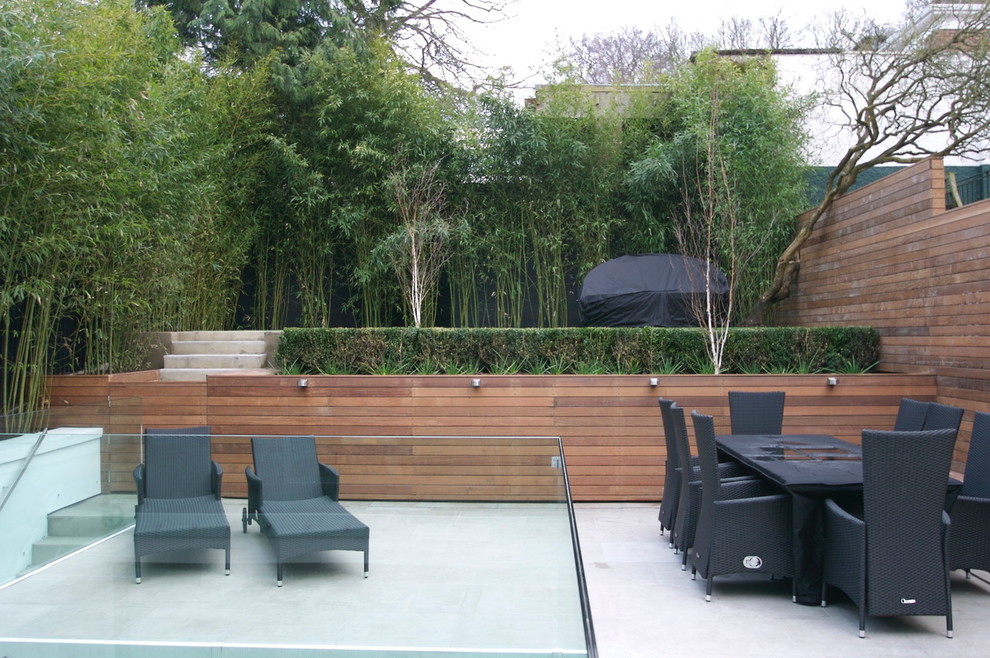 Geometrischer, Mittelgroßer Moderner Garten im Sommer, hinter dem Haus mit direkter Sonneneinstrahlung und Natursteinplatten in London