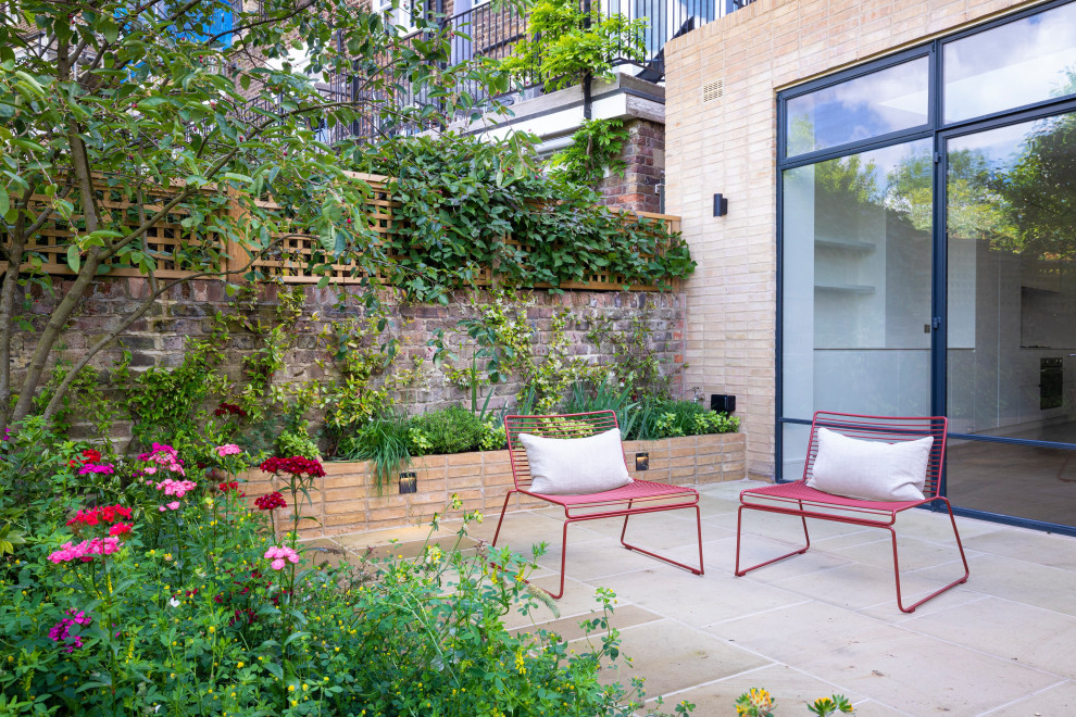 Ispirazione per un giardino design esposto in pieno sole di medie dimensioni e dietro casa in estate con pavimentazioni in pietra naturale