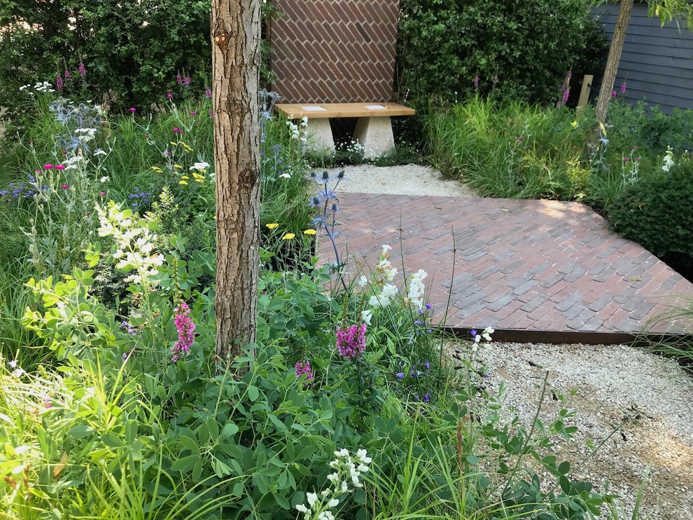 Photo of a small rustic full sun garden in London with brick paving.