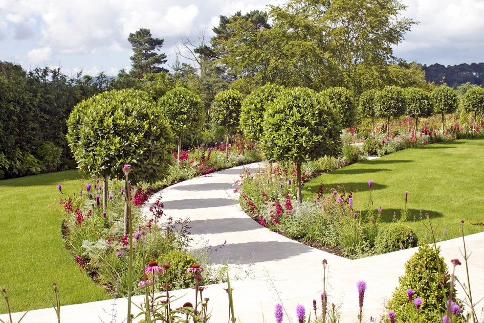 Großer Moderner Garten hinter dem Haus mit direkter Sonneneinstrahlung und Natursteinplatten in Dorset