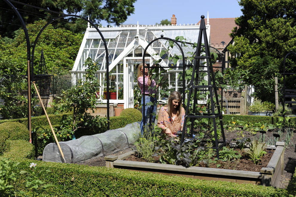 Ispirazione per un giardino vittoriano di medie dimensioni e dietro casa con pacciame