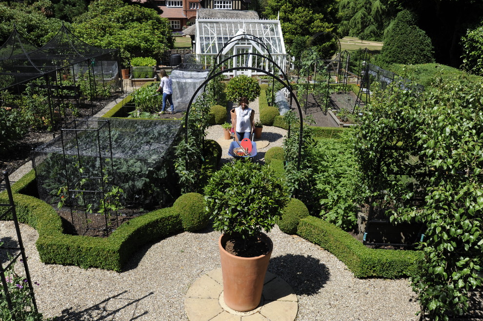 Immagine di un giardino vittoriano di medie dimensioni e dietro casa in estate con ghiaia