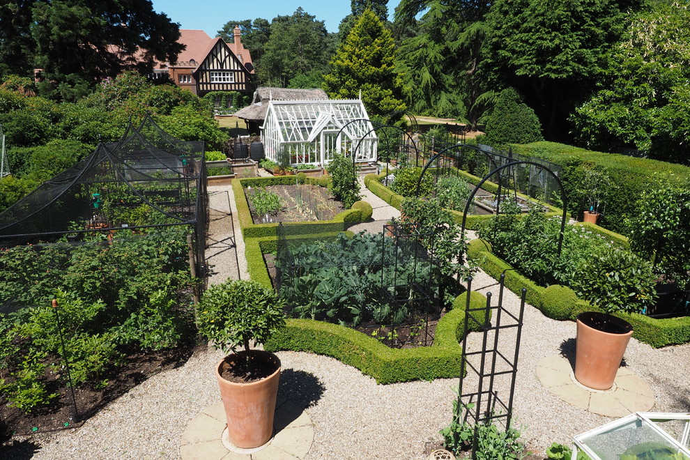 Modelo de jardín tradicional de tamaño medio en primavera en patio trasero con jardín francés, huerto y gravilla