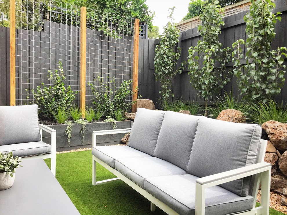 Стильный дизайн: маленький солнечный, весенний засухоустойчивый сад на заднем дворе в современном стиле с подпорной стенкой, хорошей освещенностью и мульчированием для на участке и в саду - последний тренд