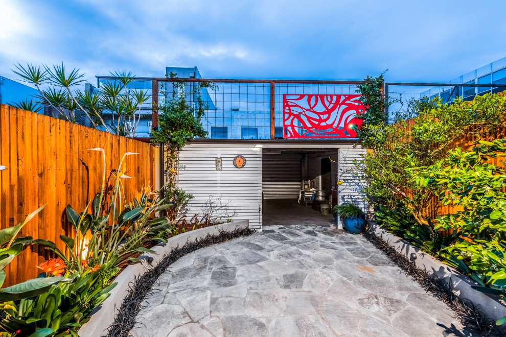 Kleiner Moderner Gartenweg im Frühling, hinter dem Haus mit direkter Sonneneinstrahlung, Natursteinplatten und Holzzaun in Melbourne