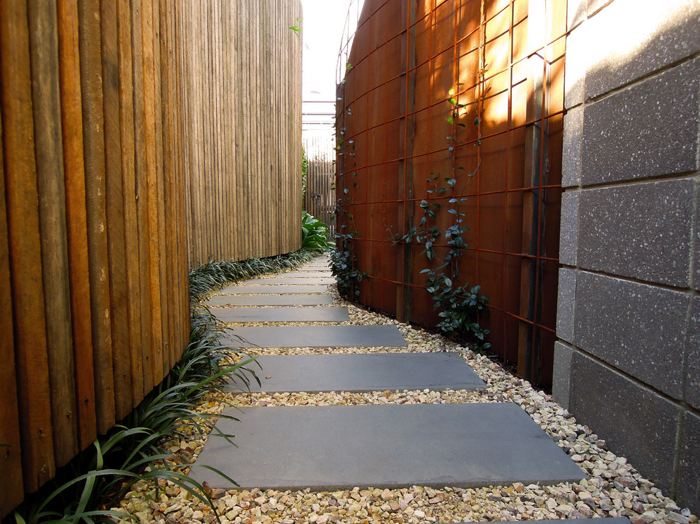 Cette photo montre un grand aménagement d'entrée ou allée de jardin avant tendance avec une exposition partiellement ombragée et des pavés en pierre naturelle.