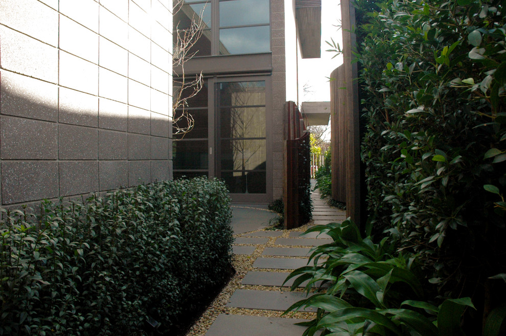 Photo of a large contemporary partial sun courtyard stone landscaping in Melbourne.