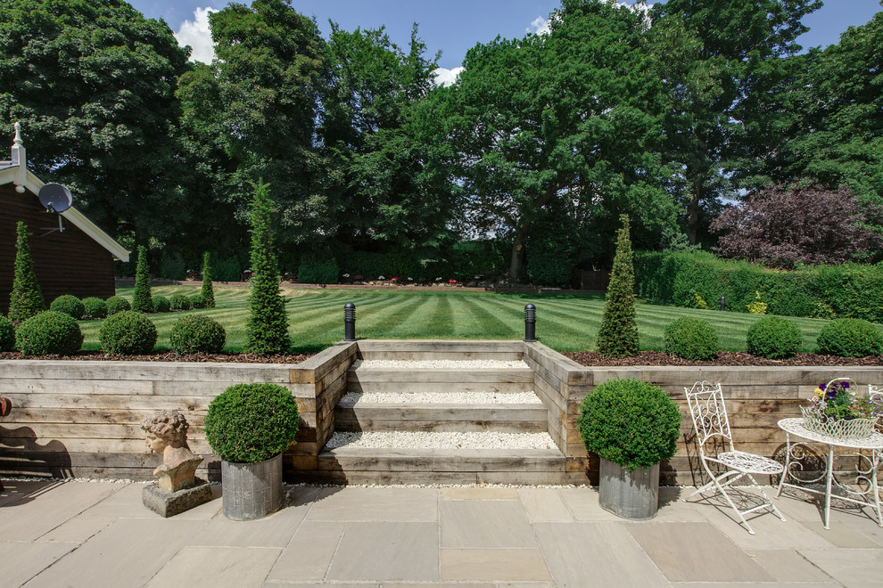 Foto di un ampio giardino tradizionale esposto in pieno sole dietro casa in estate con pavimentazioni in pietra naturale