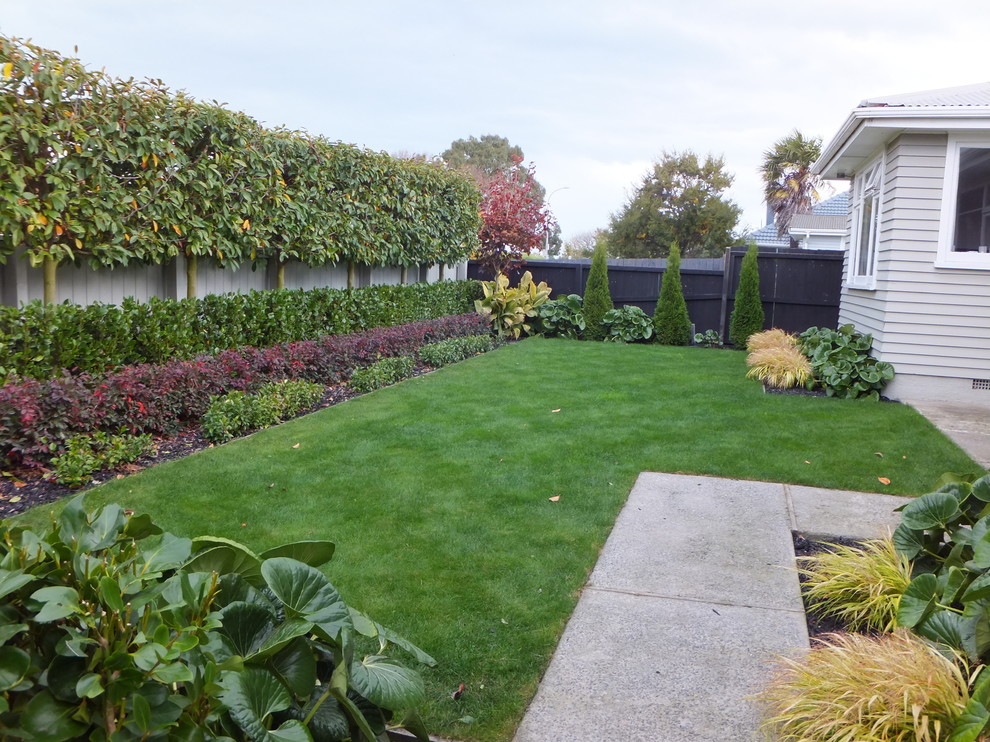 Immagine di un giardino formale chic esposto a mezz'ombra di medie dimensioni e davanti casa in primavera con un ingresso o sentiero e pavimentazioni in cemento