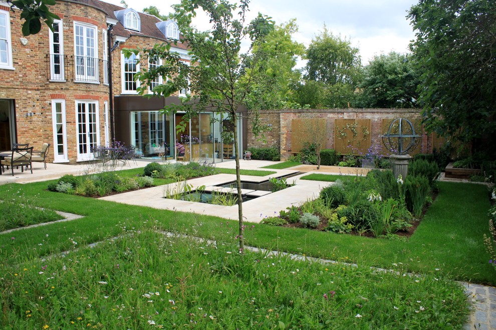 Design ideas for a medium sized traditional back partial sun garden for summer in London with concrete paving.